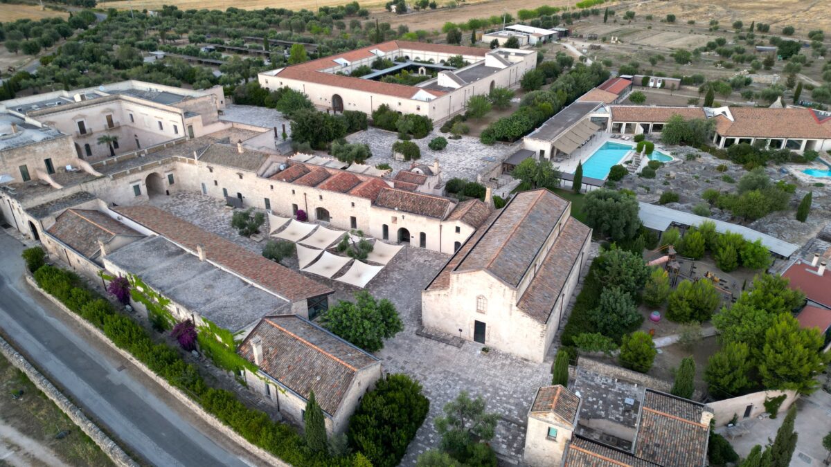 Aerial view of Relais Histò Hotel & SPA, showcasing its architecture, courtyard, pool, and surrounding landscape.