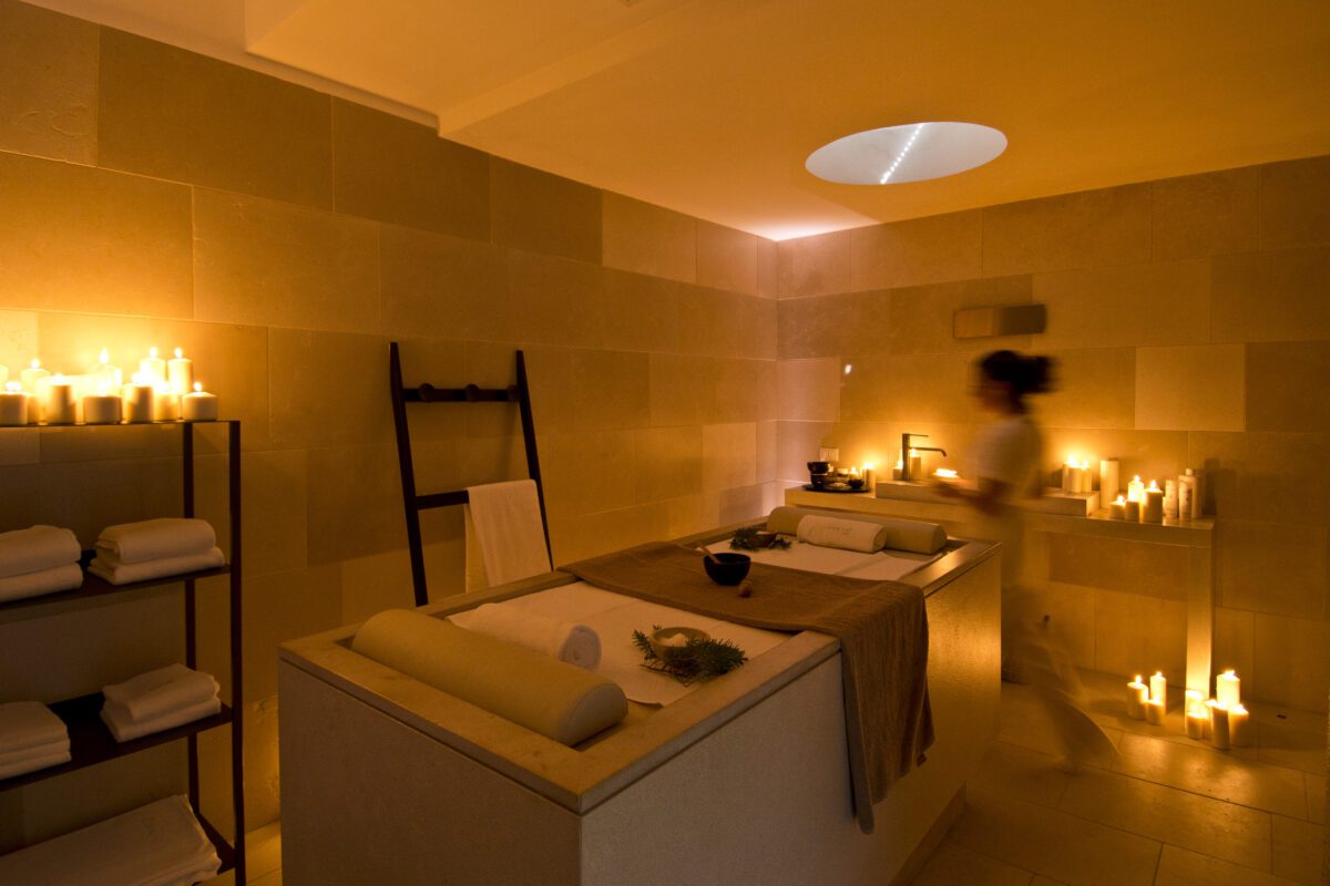 Spa treatment room at Relais Histò Hotel, lit by candles, creating a relaxing ambiance.
