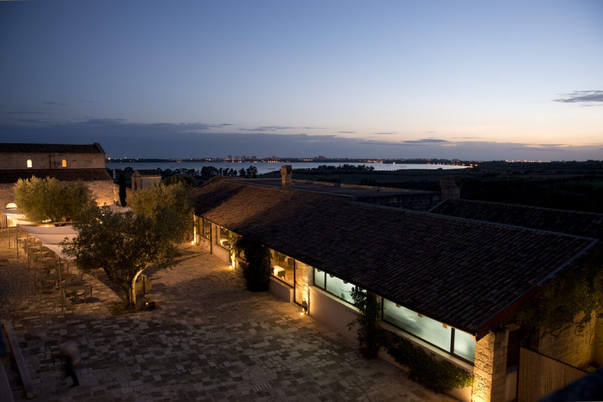 Relais Histò Hotel at dusk: Courtyard, building, and distant city lights.