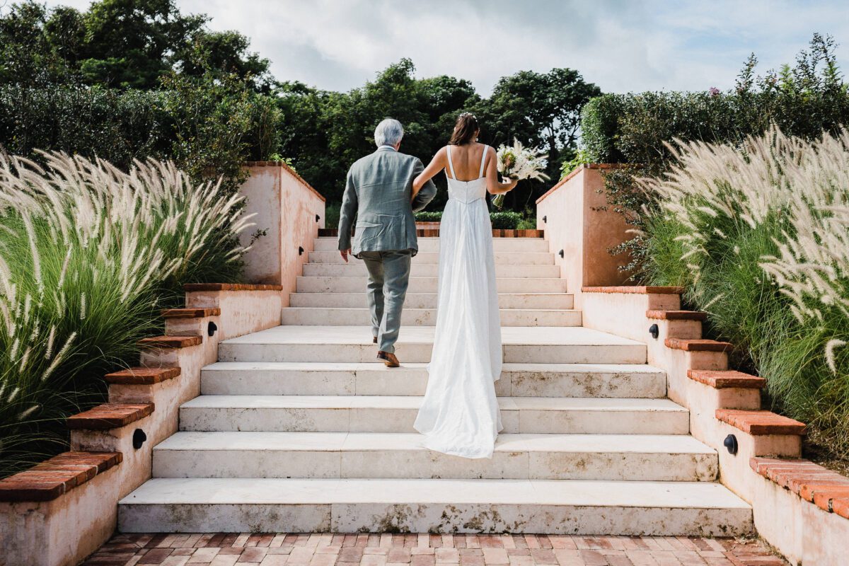 Bride and father walking up stairs at Rancho Santana wedding venue.