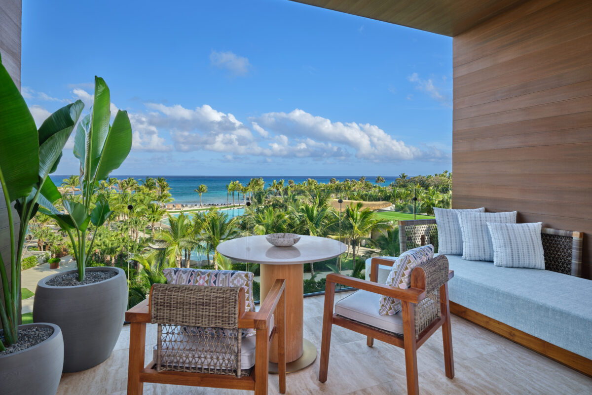 Balcony view at The St. Regis Cap Cana Resort overlooking pool, palm trees, and ocean. Exclusive wedding resort in Punta Cana.