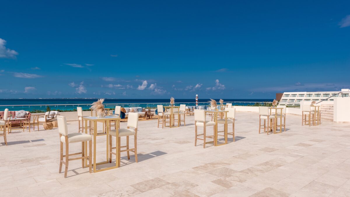 Luxury wedding venue in Cancun with ocean view and stylish cocktail tables.