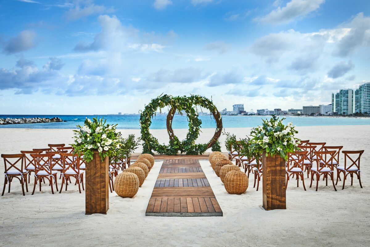 Beach wedding setup at Hyatt Ziva Cancún, a luxury wedding venue in Cancun, with floral arrangements and ocean view.