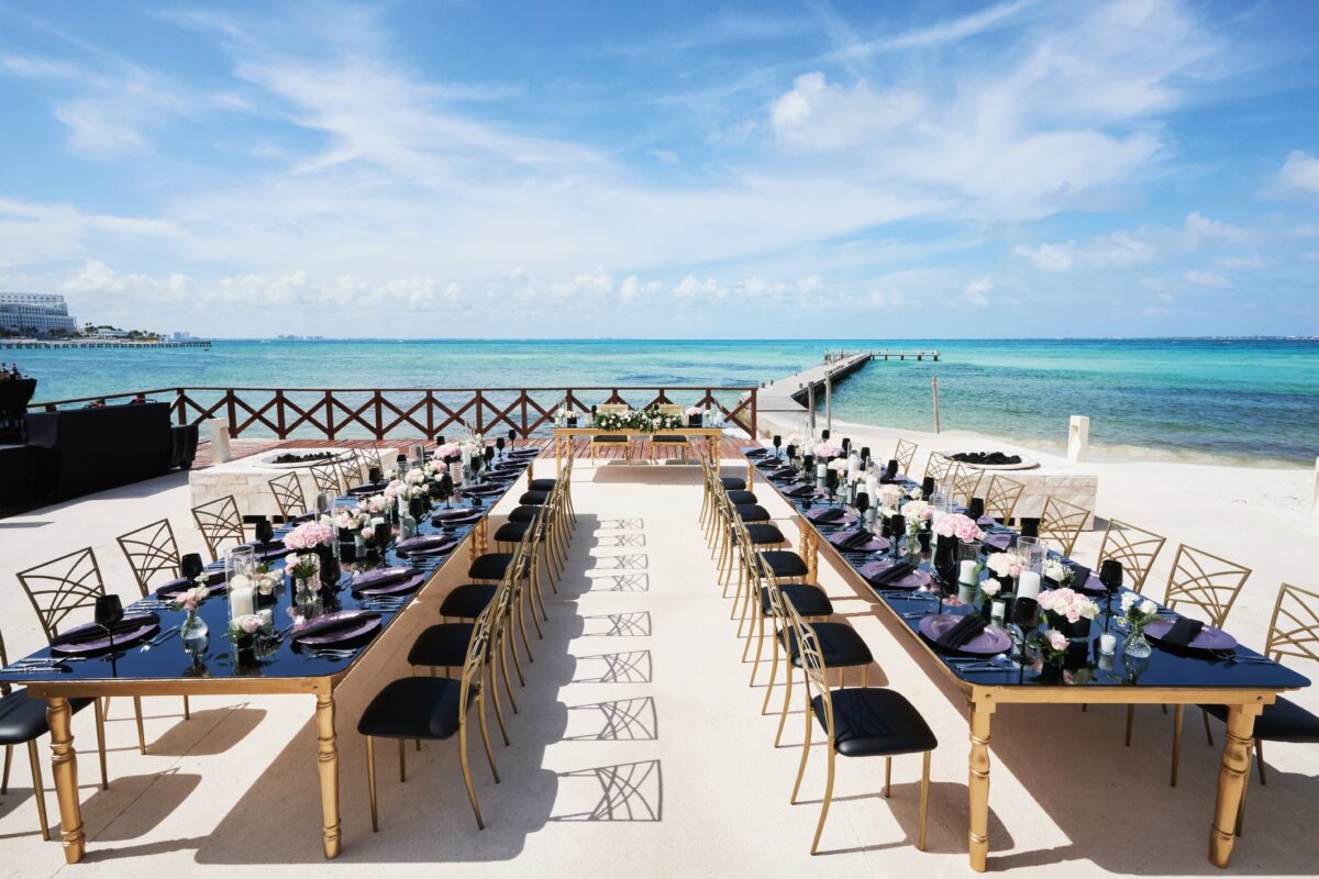 Luxury wedding venue in Cancun with long tables set on a beautiful beach.