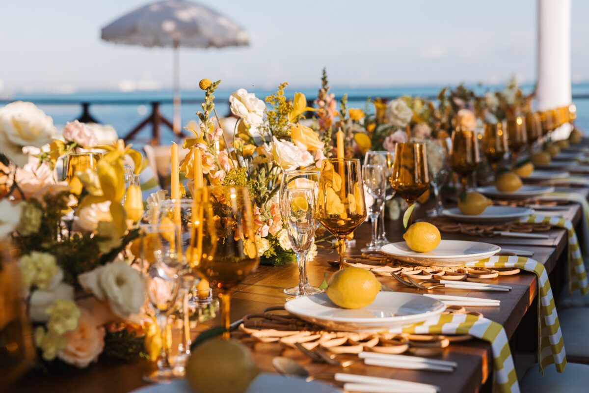 Luxury wedding venue in Cancun: Elegant table setting with yellow flowers and lemons by the ocean.