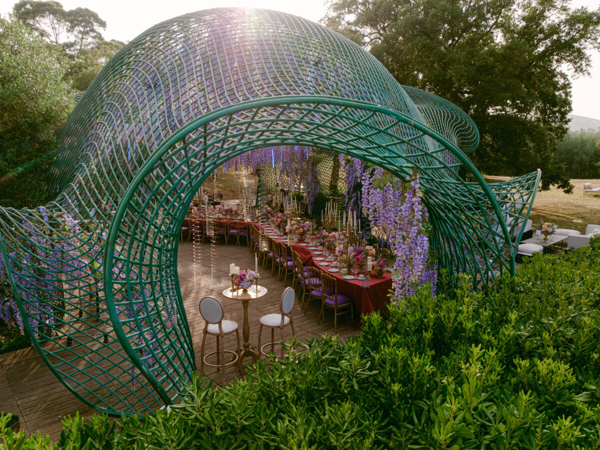 Luxury wedding in Saint-Tropez: Elaborate green arbor over a long reception table.