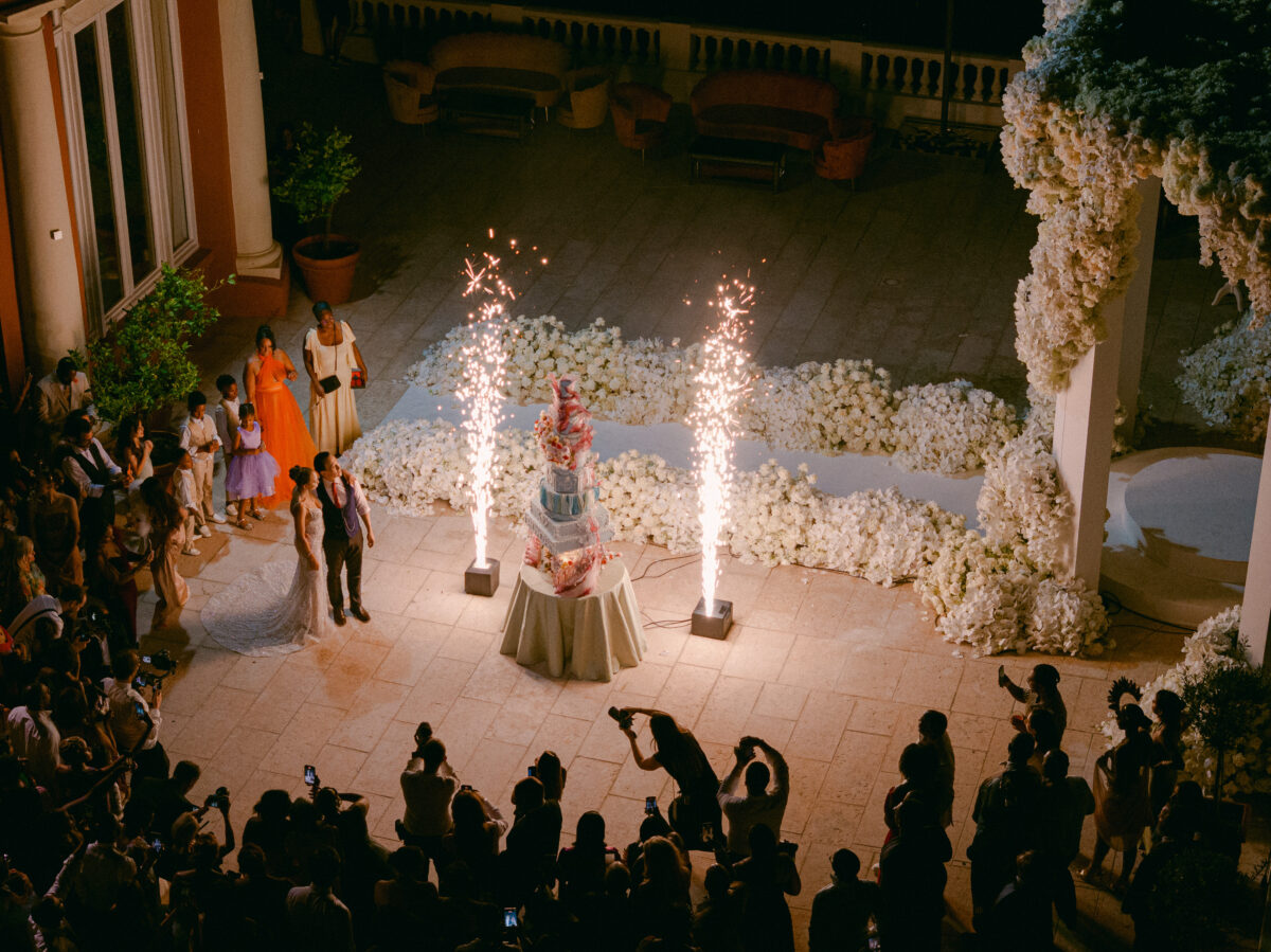 Luxury wedding in Saint-Tropez at COMO Le Beauvallon: Bride and groom with sparklers and multi-tiered cake.