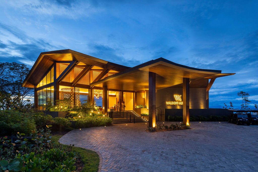 Waldorf Astoria Costa Rica entrance at dusk, showcasing modern architecture and lush landscaping.