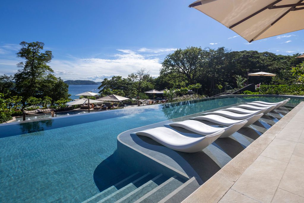 Waldorf Astoria Costa Rica infinity pool with lounge chairs and ocean view.