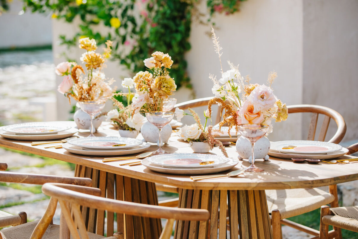 Wedding table setting with flowers, plates, and glasses. Best wedding planning websites can help with decor ideas.