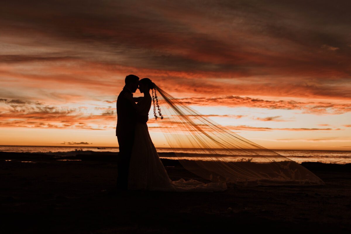 Silhouette of bride and groom embracing on a beach at sunset, Rancho Santana