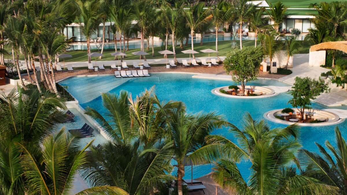 St. Regis Cap Cana Resort pool with palm trees, a luxury destination for exclusive weddings in Punta Cana.