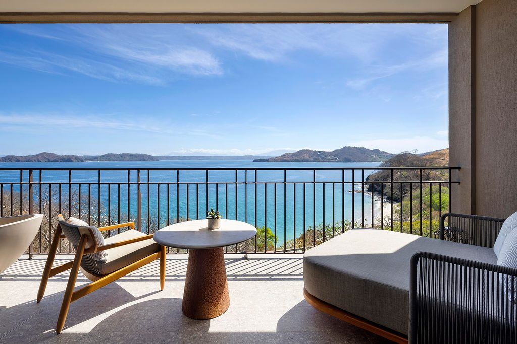 Balcony view at Waldorf Astoria Costa Rica, with ocean, chair, and chaise lounge.