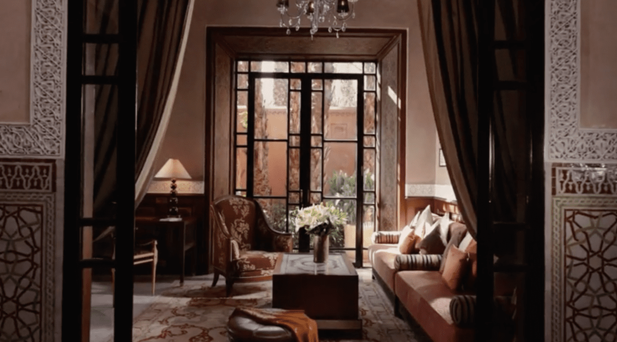 Elegant luxury hotel room design with seating area, chandelier, and ornate tile details.