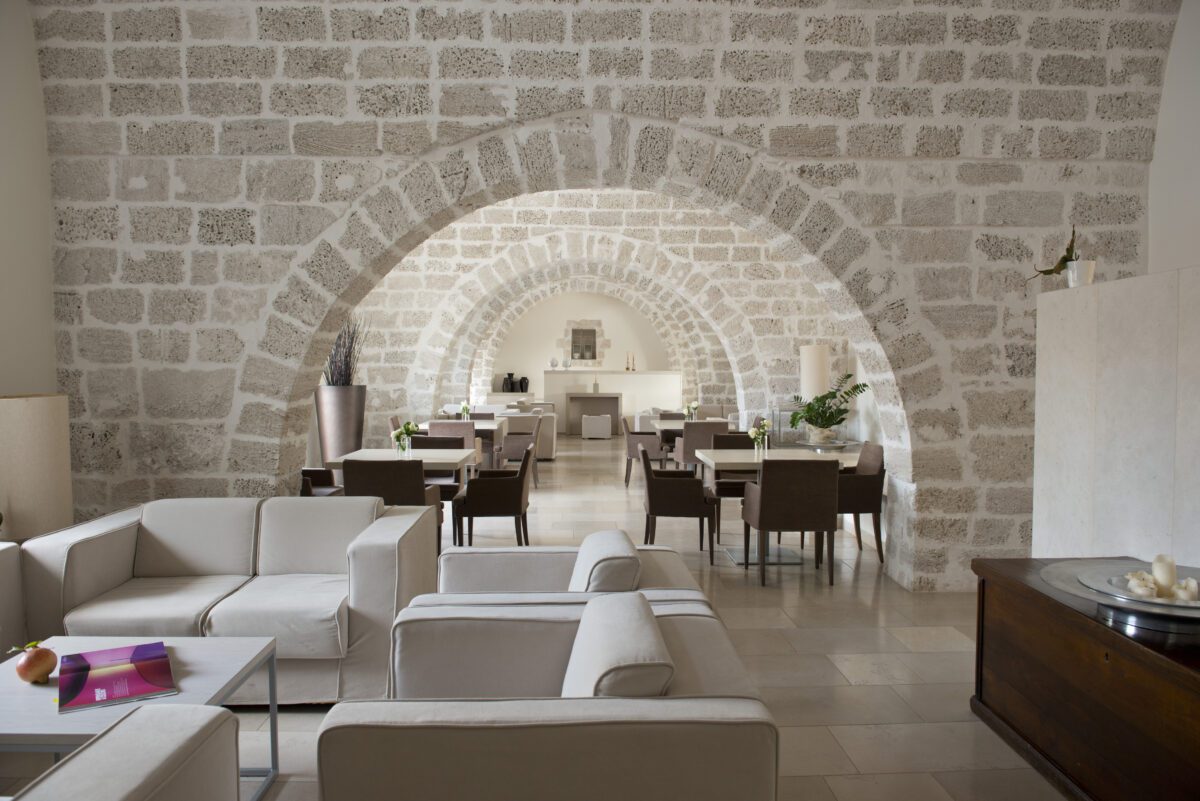 Relais Histò Hotel & SPA interior with stone arches, seating area, and dining tables.