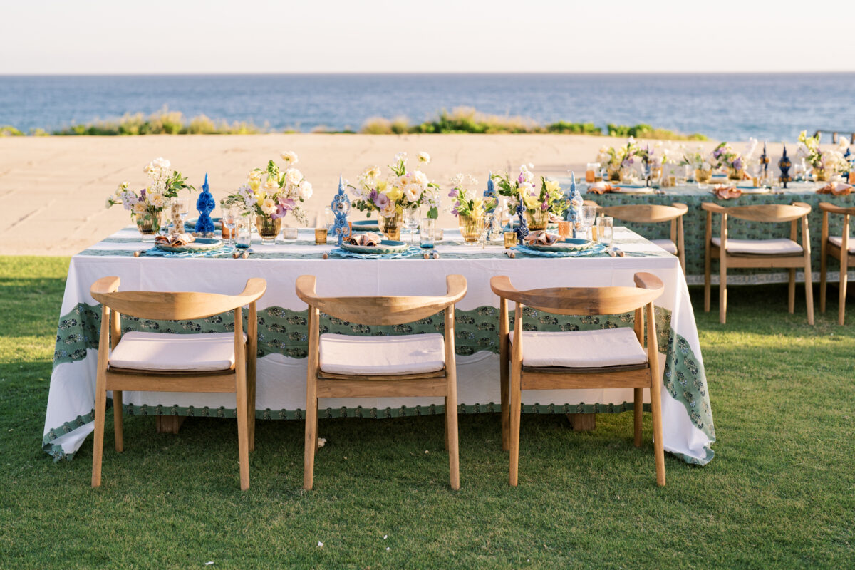 Beach wedding reception with floral centerpieces and ocean view.