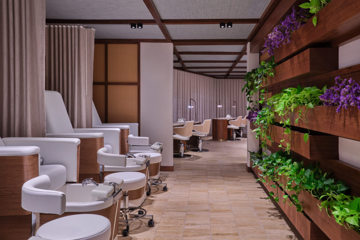 Spa interior at The St. Regis Cap Cana Resort, with pedicure chairs and a plant wall.