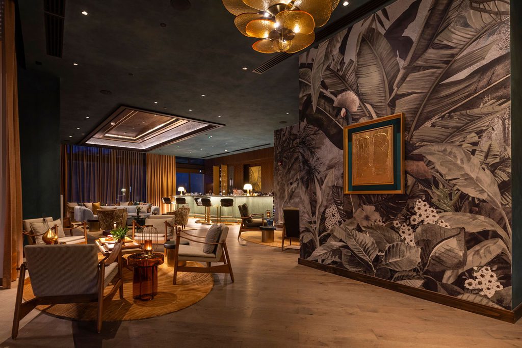 Waldorf Astoria Costa Rica lobby with tropical mural, stylish seating, and modern lighting.