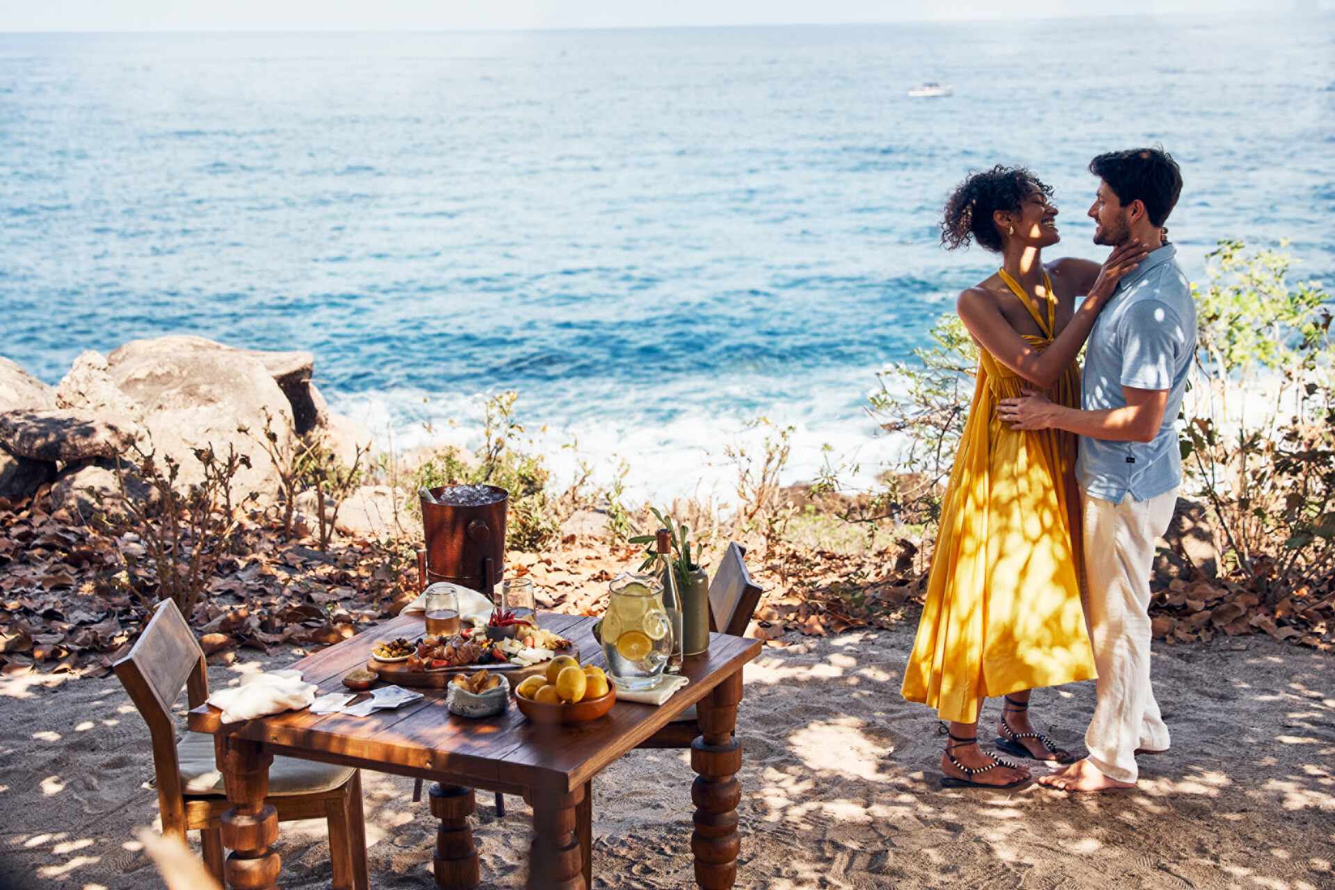Romantic seaside dinner for a luxury honeymoon 2026. Couple embracing by the ocean.