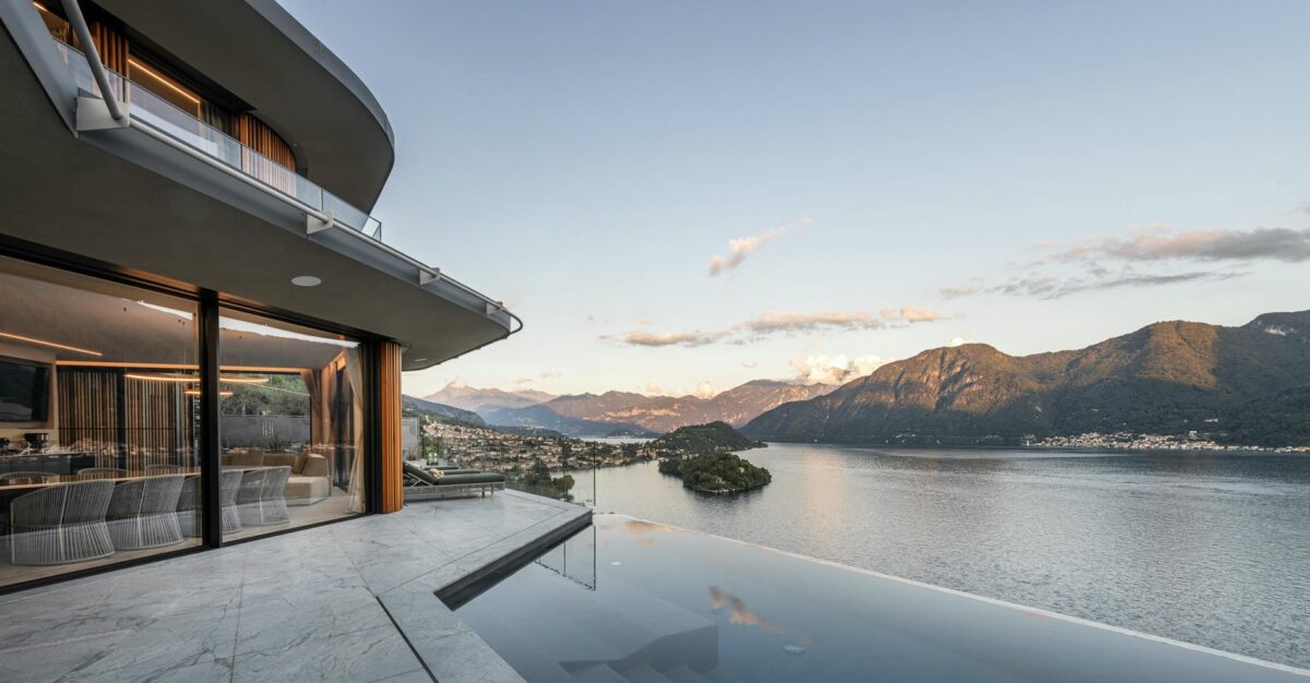Luxury villa rental with infinity pool overlooking a stunning lake and mountain view.