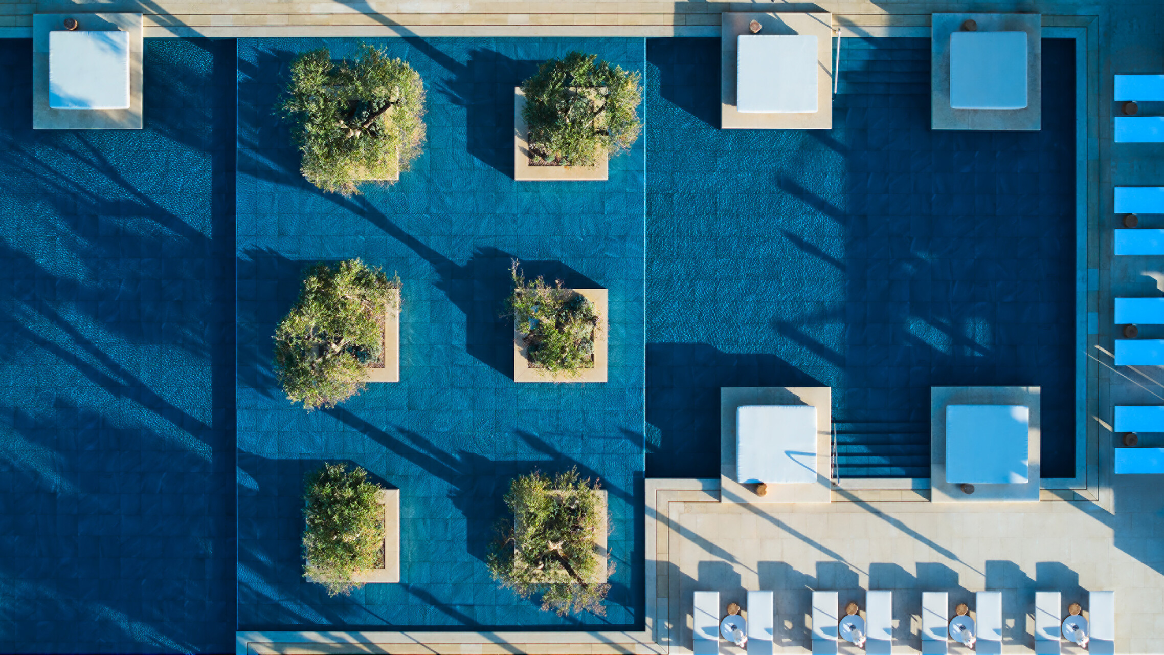 Four Seasons Astir Palace Athens: Aerial view of pool with trees and lounge chairs.