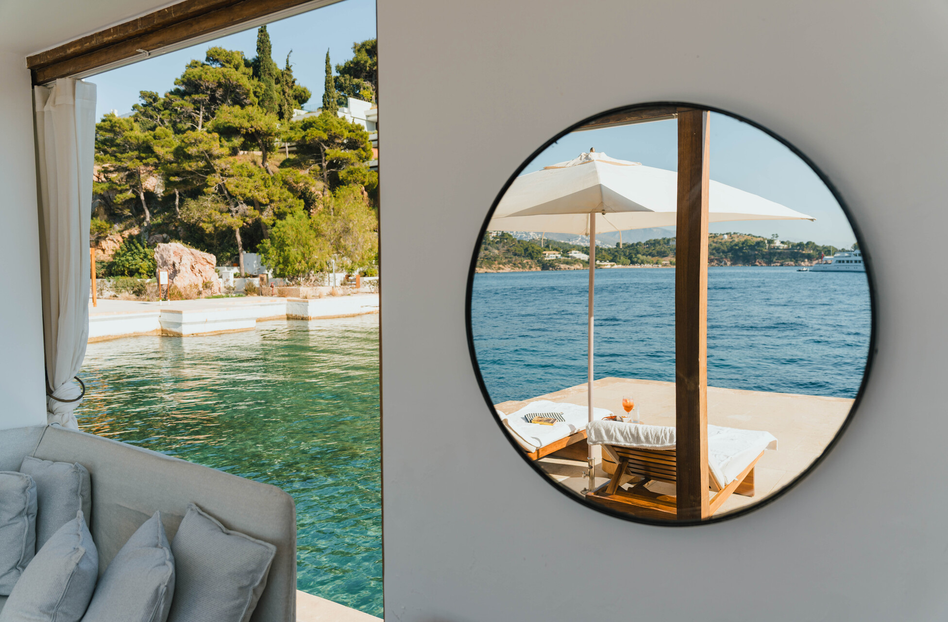 View from Four Seasons Astir Palace room to the sea with lounge chairs.