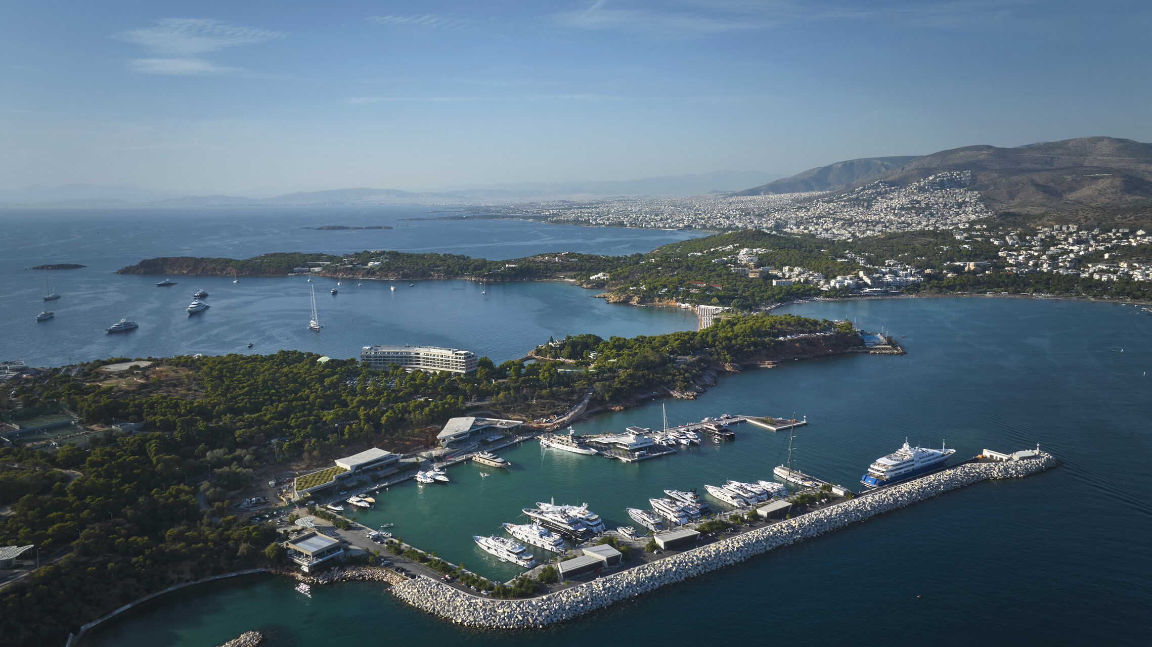 Aerial view of the Four Seasons Astir Palace Hotel Athens marina, showcasing luxury yachts and the coastline.
