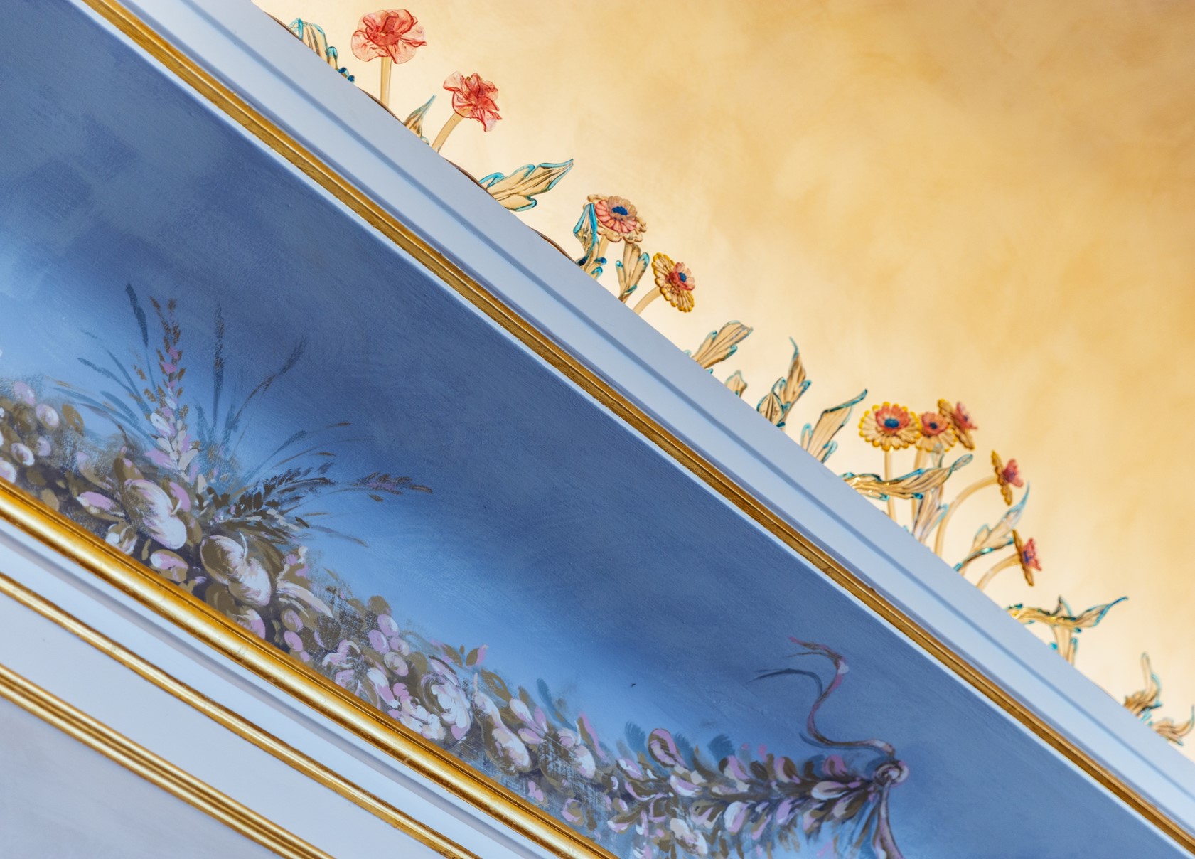 Ornate floral ceiling detail at the Royal Hotel Sanremo, featuring gold trim and blue accents.