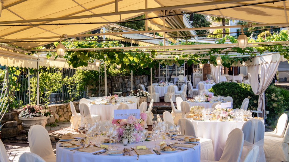 Elegant wedding reception at Royal Hotel Sanremo, featuring round tables with floral centerpieces and white linens.