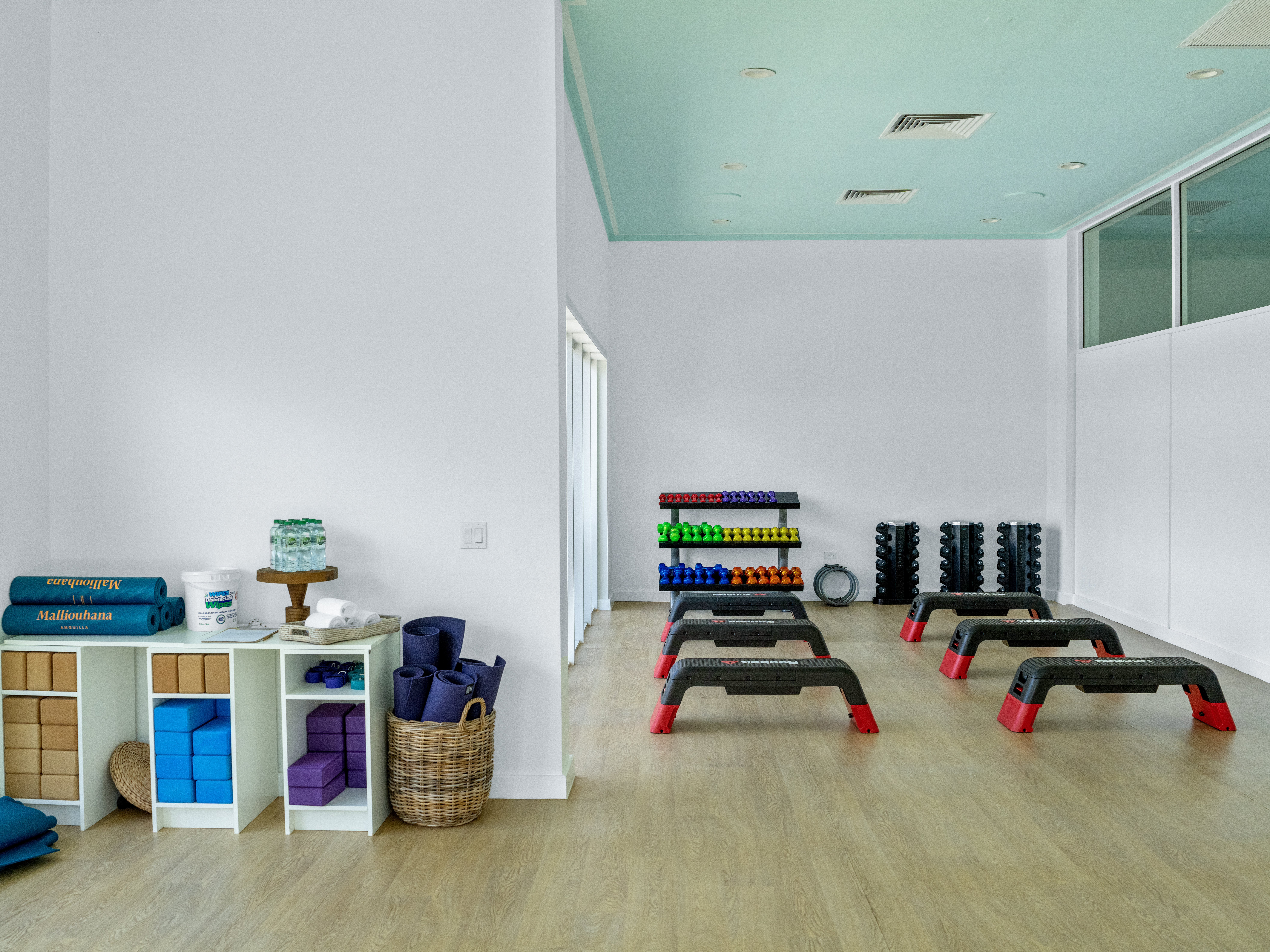 Fitness studio with yoga mats, weights, and step platforms