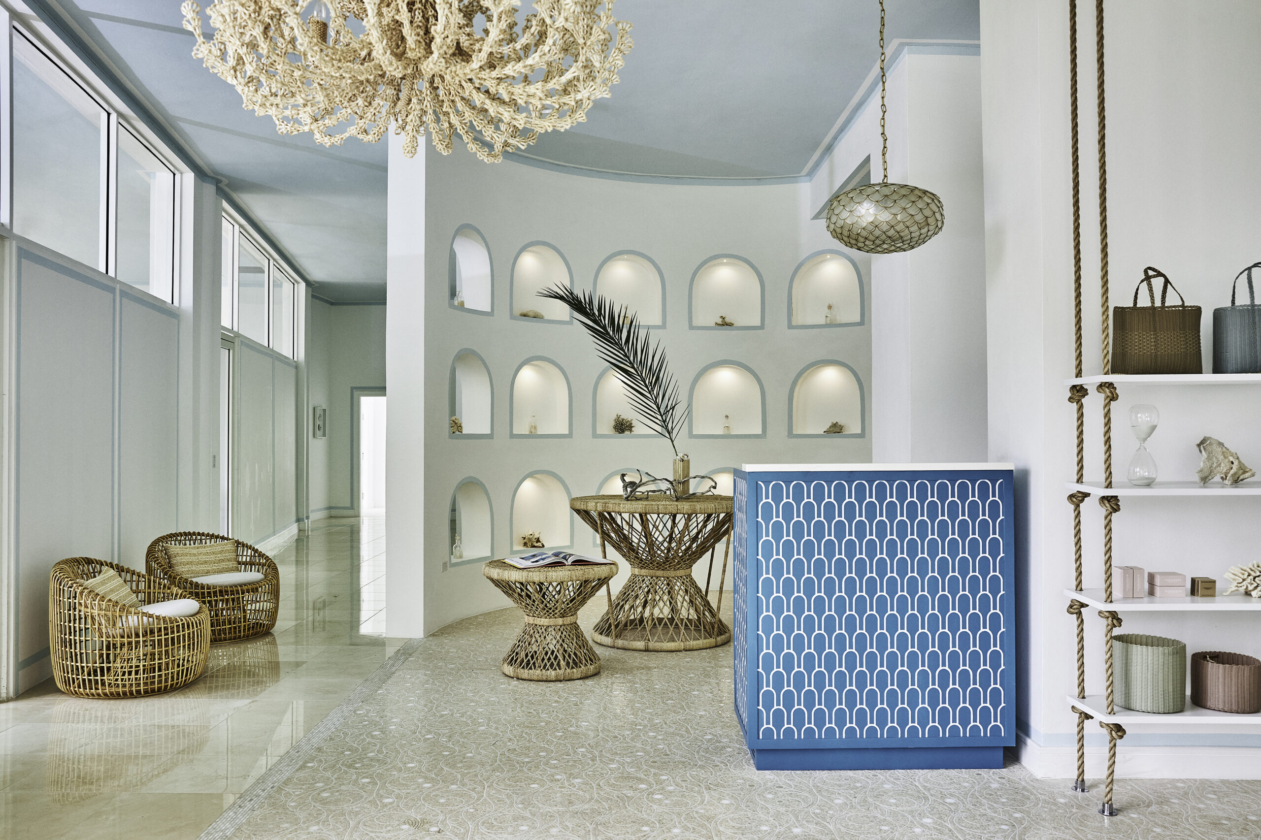 Malliouhana hotel lobby with wicker furniture and blue accents.