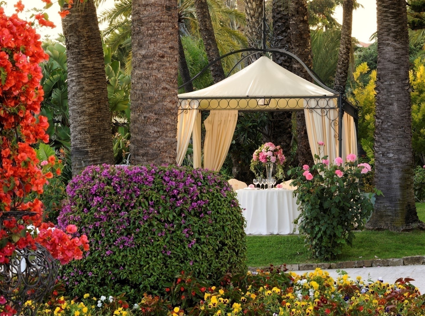 Luxury wedding venue in Sanremo: Elegant gazebo with floral decorations in a lush garden setting.