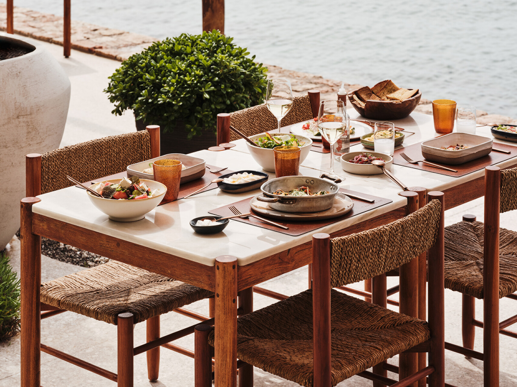 Outdoor dining at Four Seasons Astir Palace Hotel Athens with a marble table set for lunch by the sea.