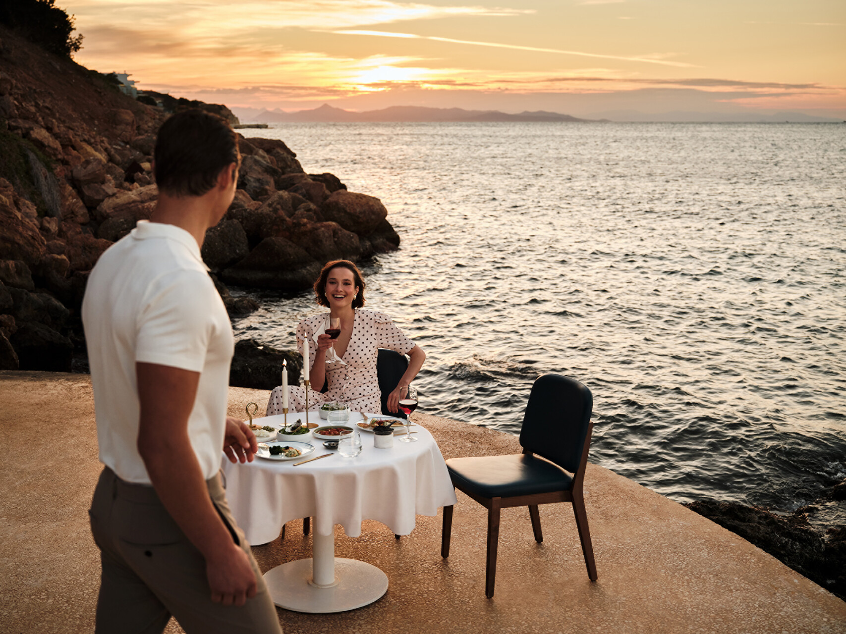 Romantic seaside dinner at Four Seasons Astir Palace Hotel Athens during sunset.