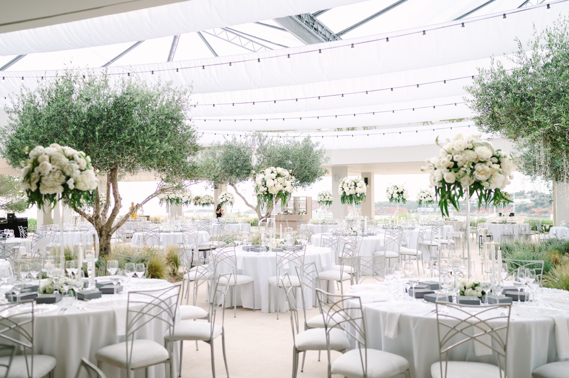 Elegant Four Seasons Astir Palace Hotel Athens wedding reception with white decor and olive trees.
