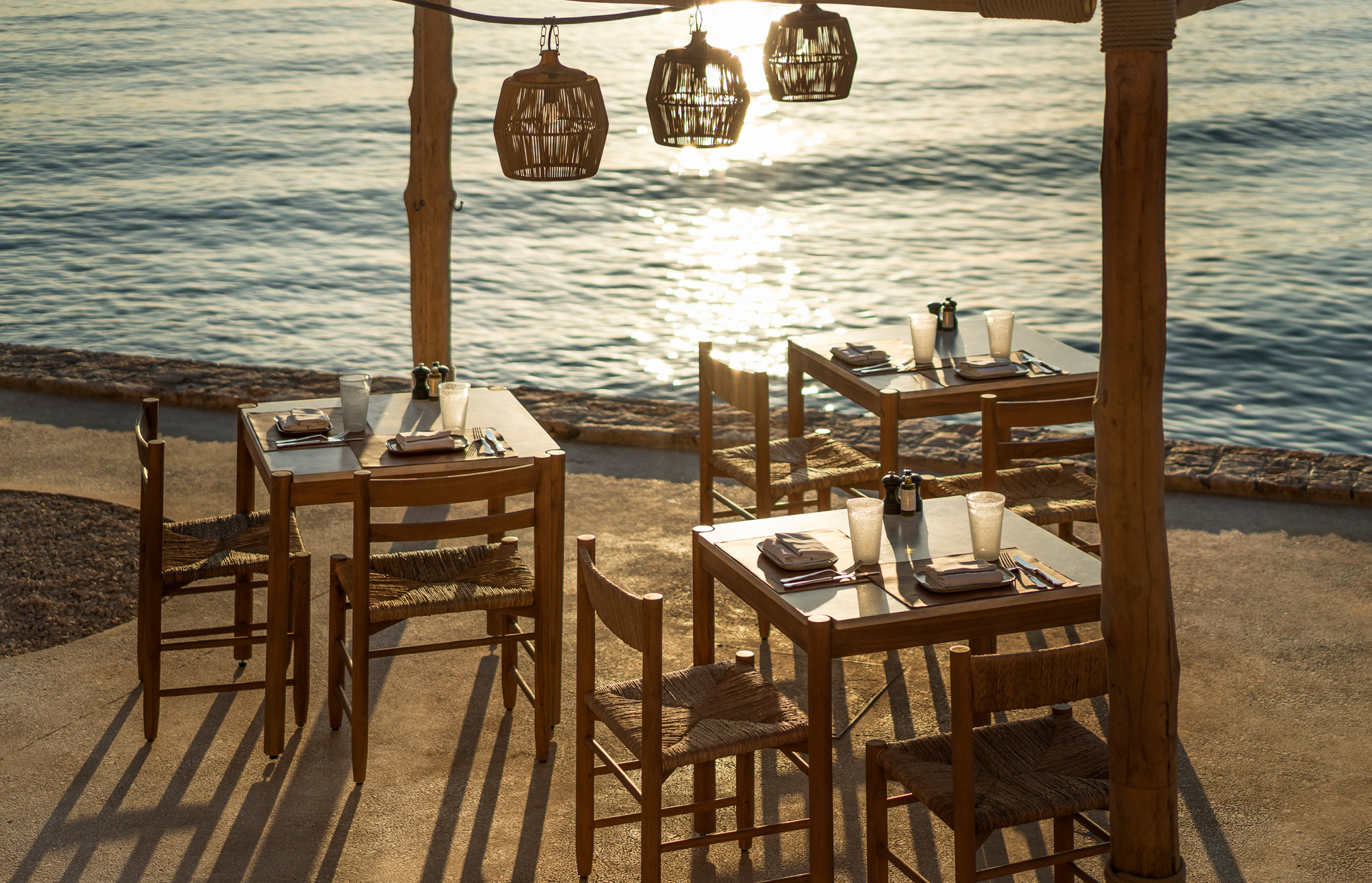 Seaside dining at Four Seasons Astir Palace Hotel Athens, featuring tables with ocean views.