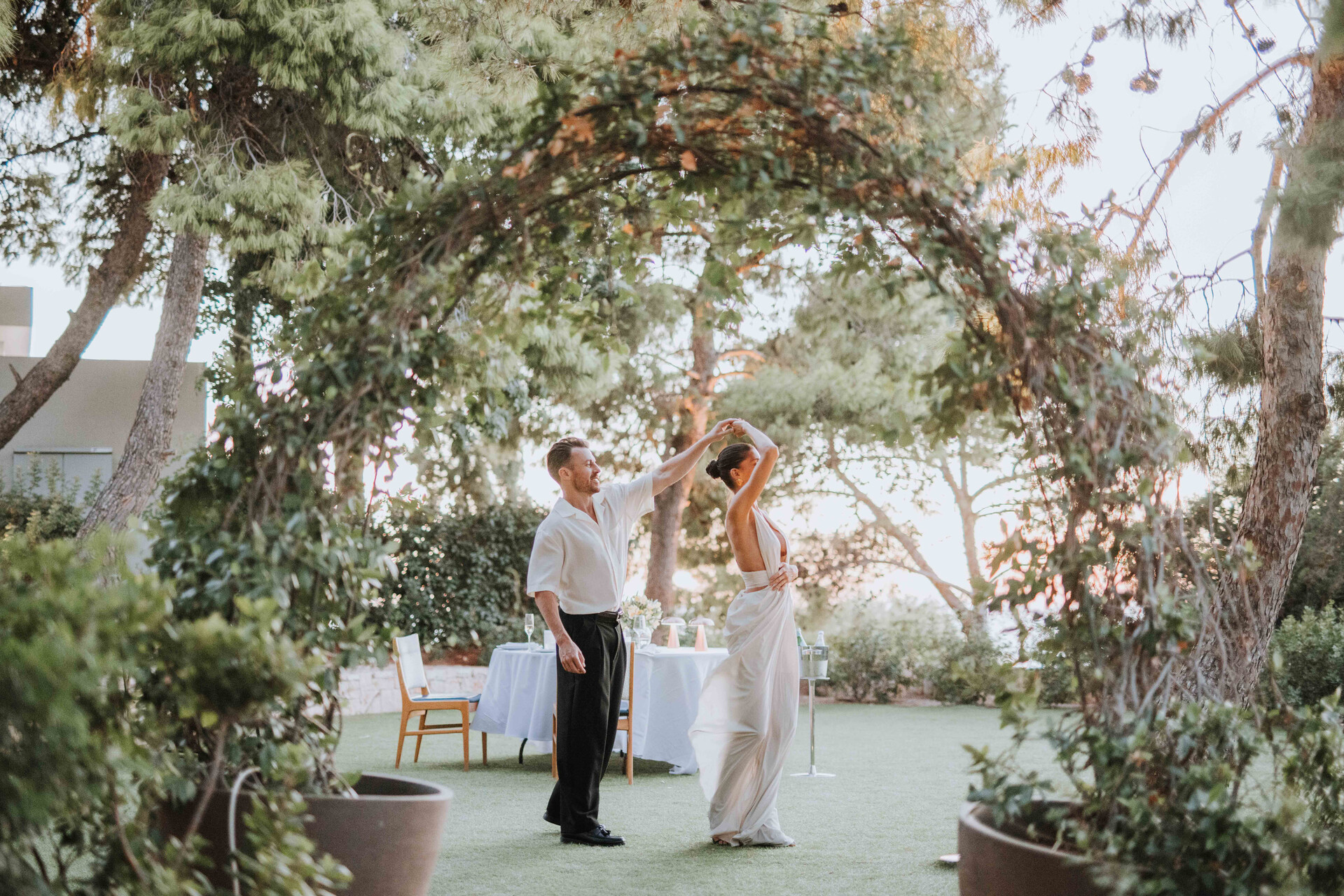 Couple dancing under greenery at Four Seasons Astir Palace Hotel Athens wedding.