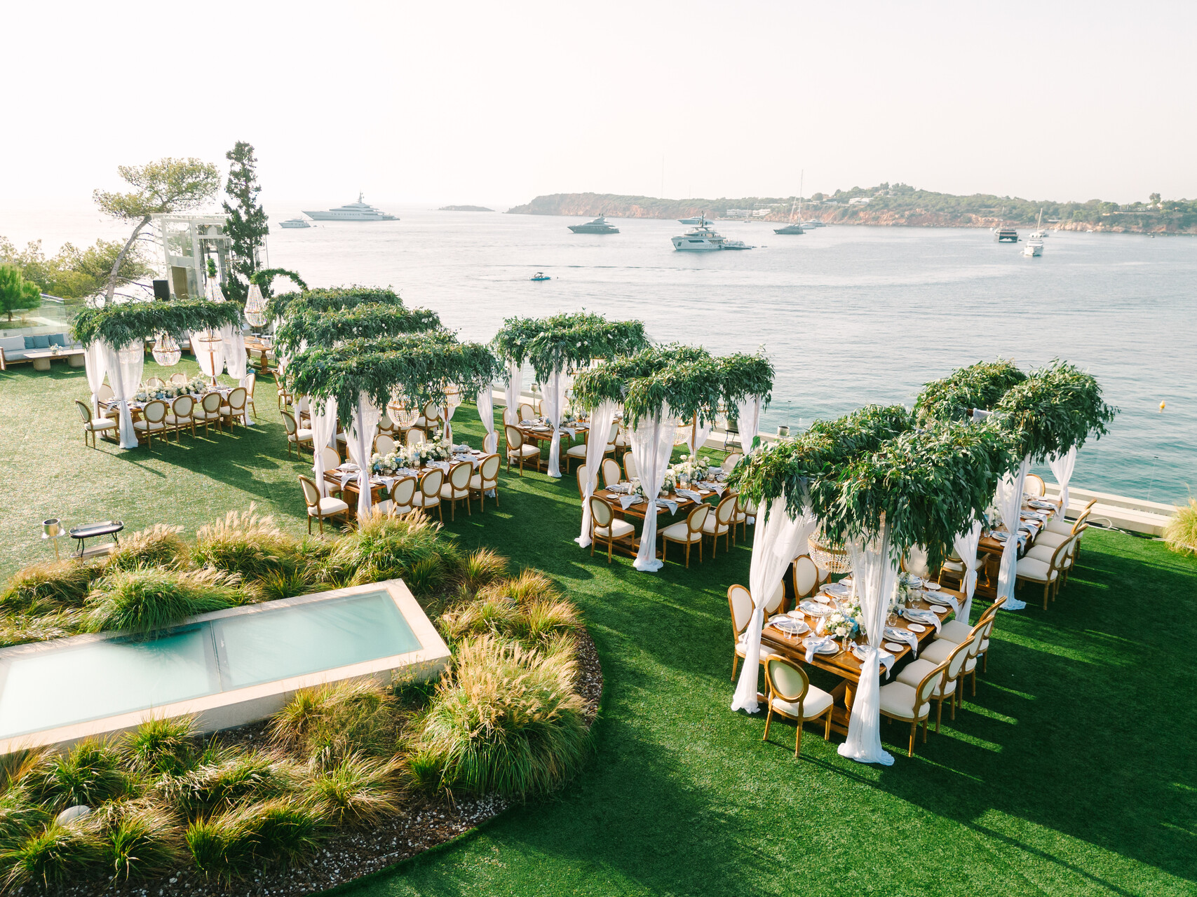Outdoor wedding reception at Four Seasons Astir Palace, Athens. Tables with greenery and ocean views.