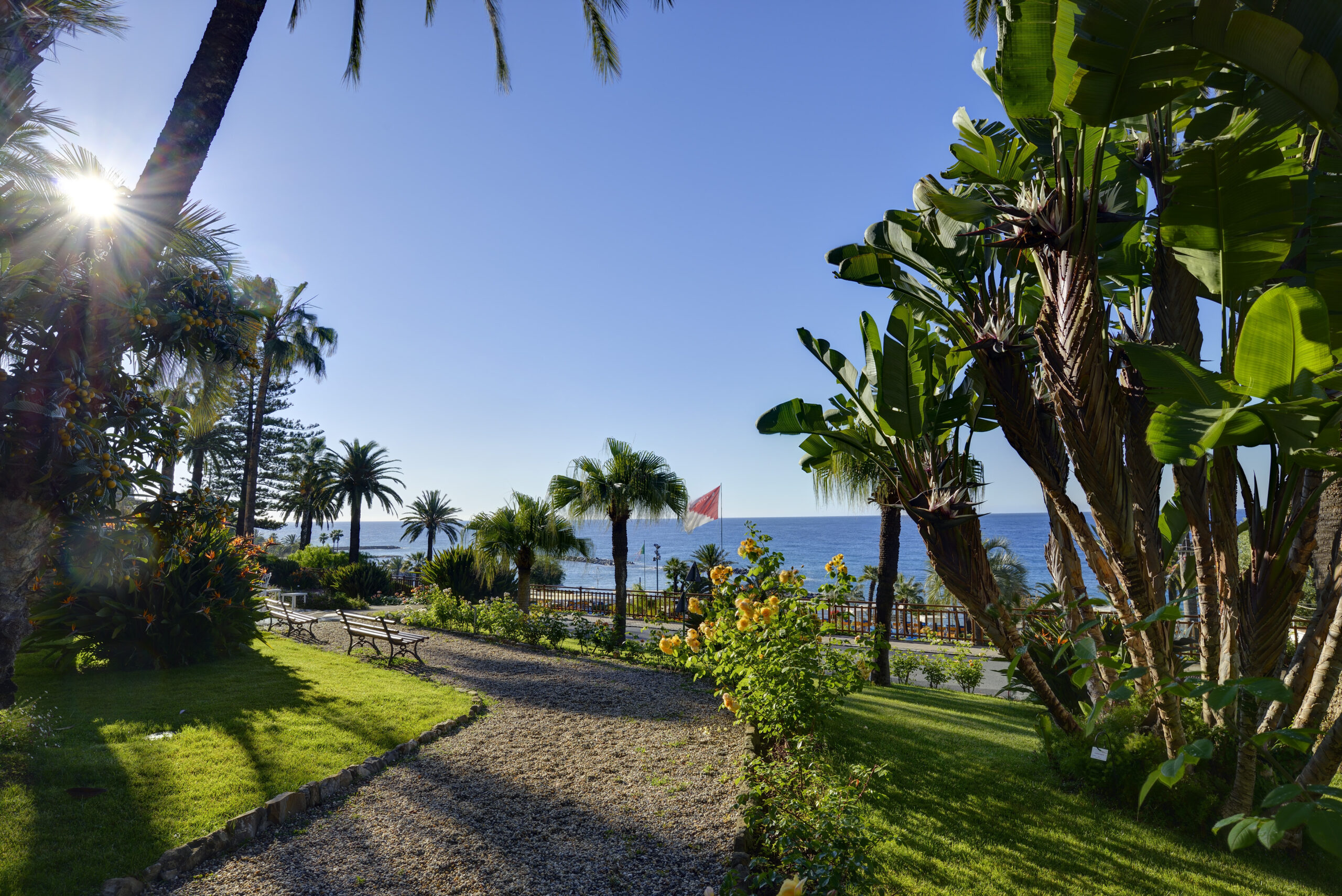 Path through lush gardens at Royal Hotel Sanremo, a luxury wedding venue, leading to the sea.