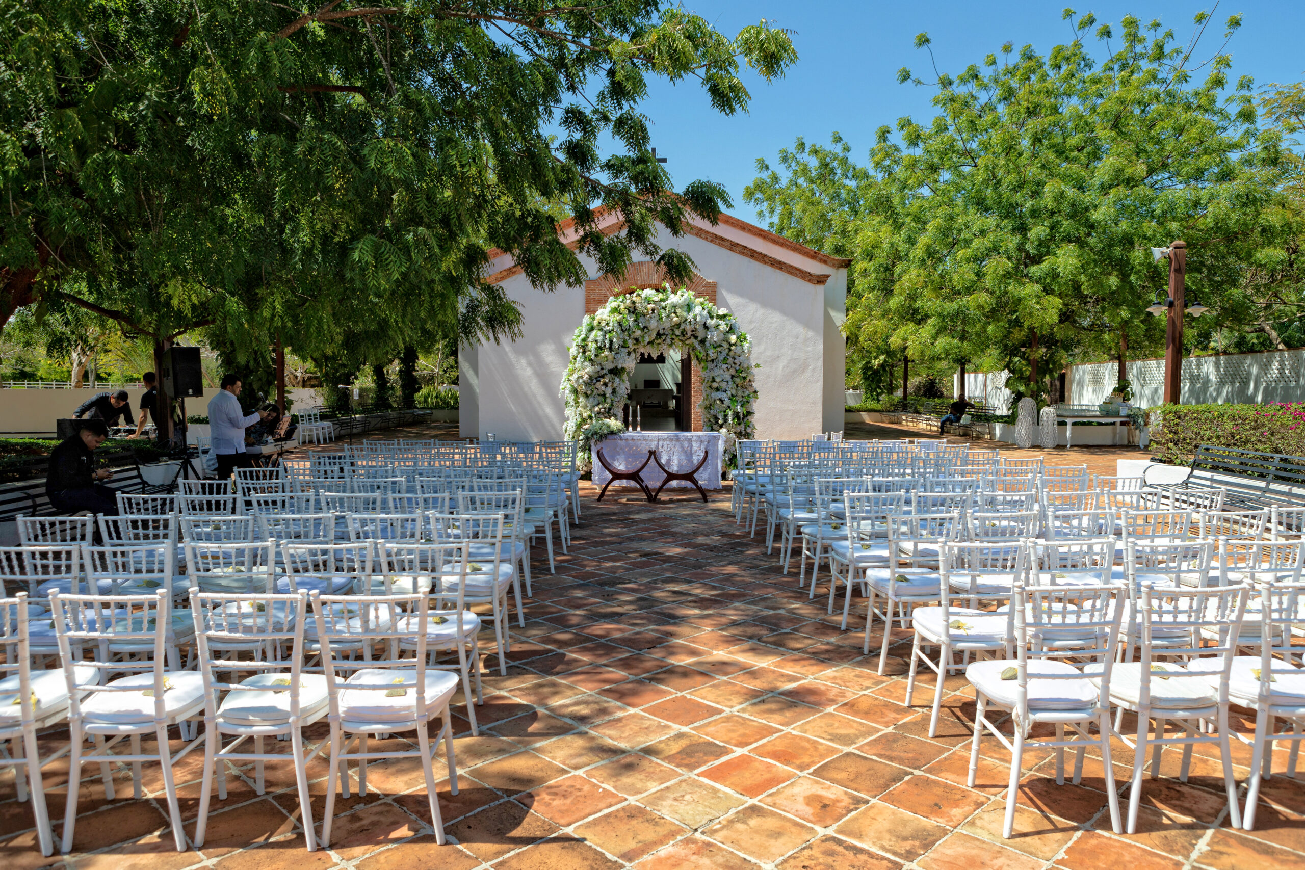 Ceremony setup at a Caribbean venue with white chairs and floral arch