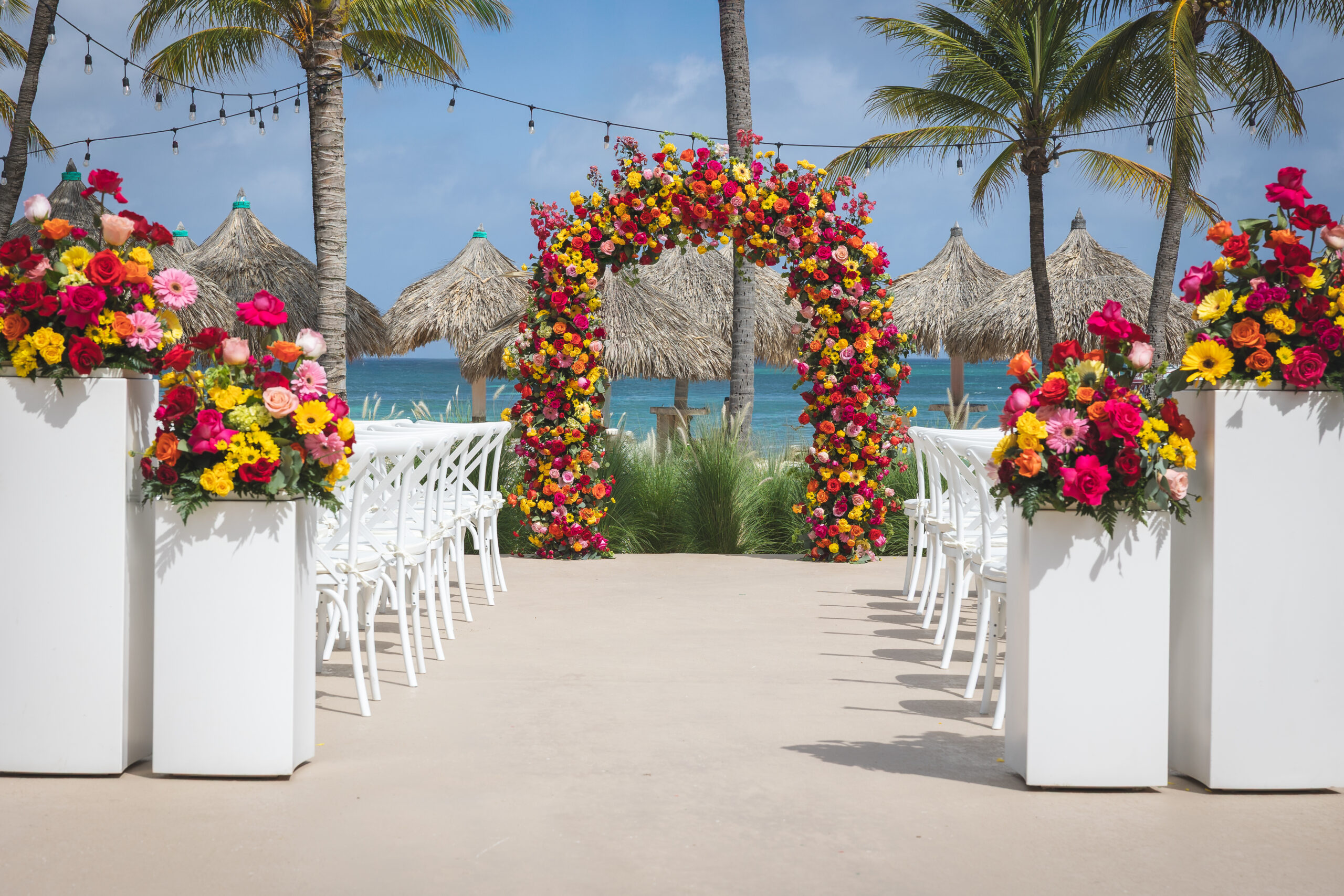 Beach wedding archway decorated with colorful flowers at one of the best Caribbean destination wedding venues.