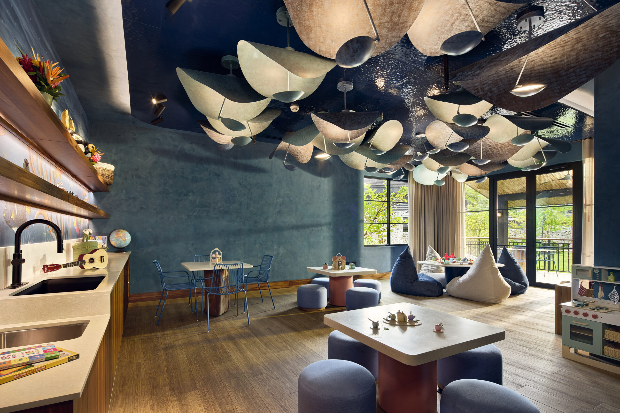 Nekajui Ritz-Carlton Reserve kids' playroom with tables, beanbag chairs, and playful ceiling lights.