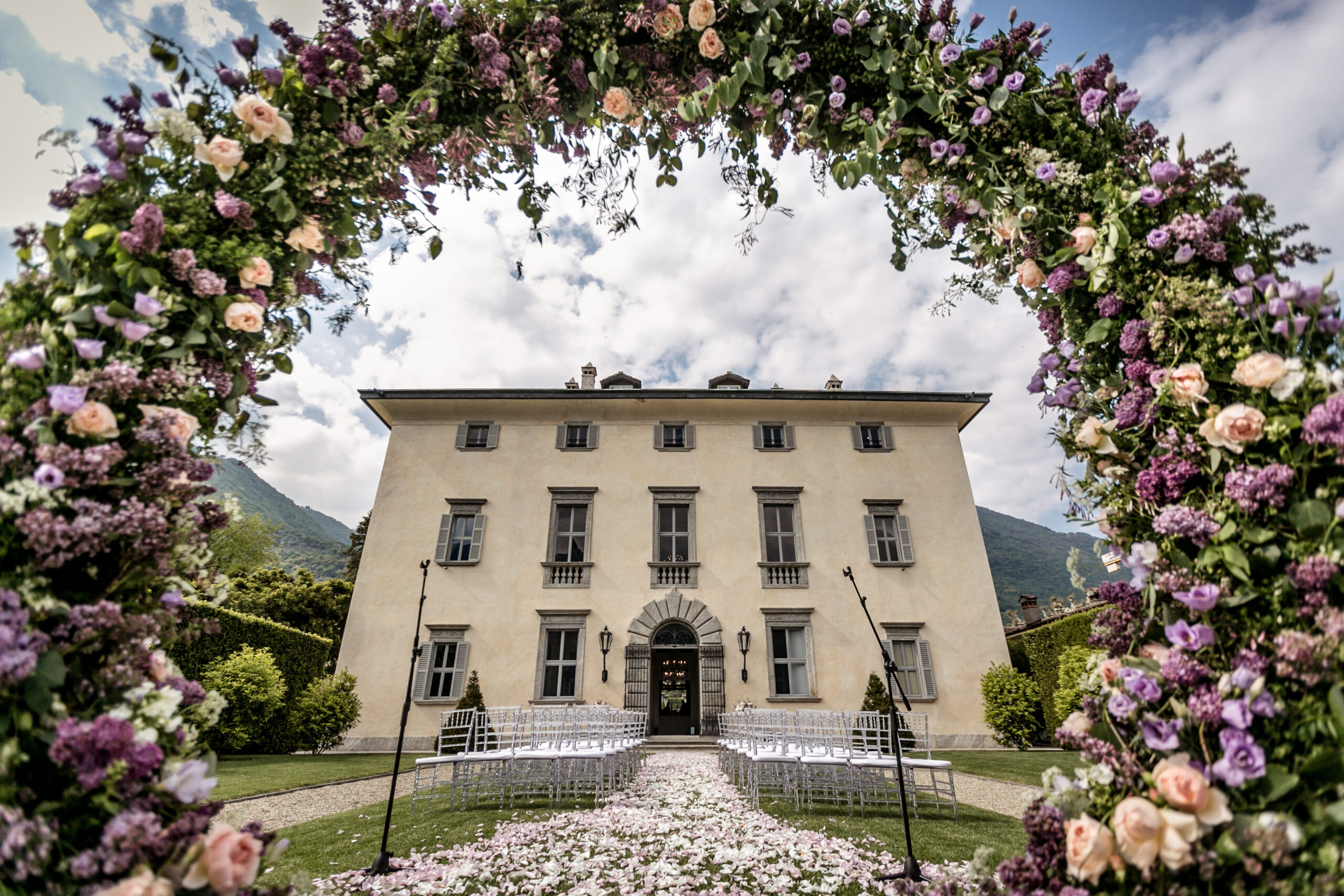 Floral arch frames a villa, perfect for private celebration villas in Italy.