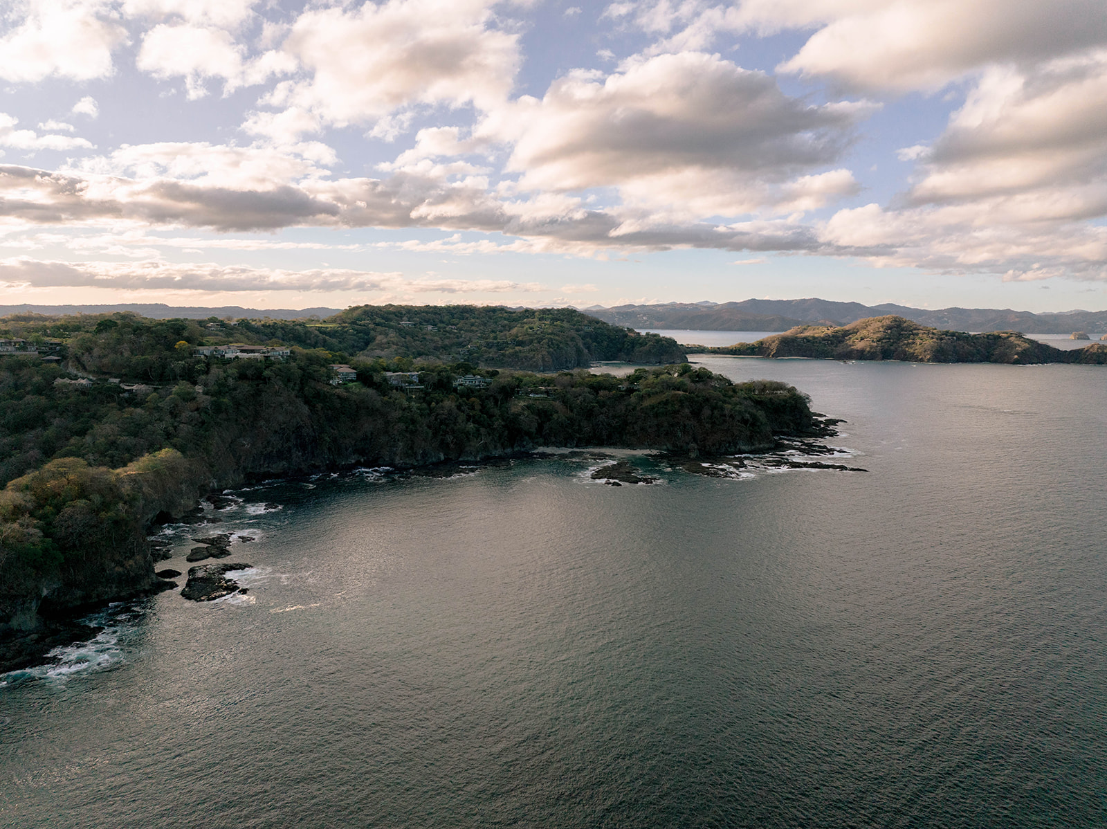 Nekajui, a Ritz Carlton Reserve: Aerial view of coastline with lush green hills and ocean.