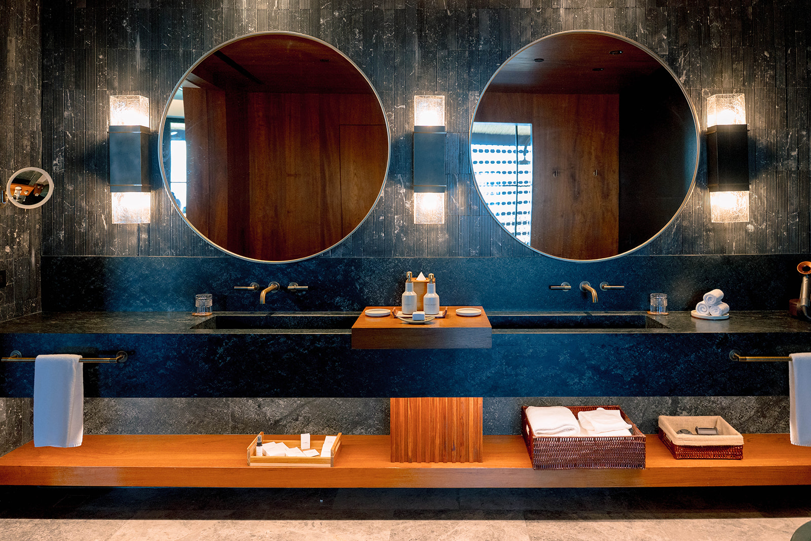 Luxurious bathroom at Nekajui, a Ritz Carlton Reserve, featuring double sinks, round mirrors, and elegant lighting.