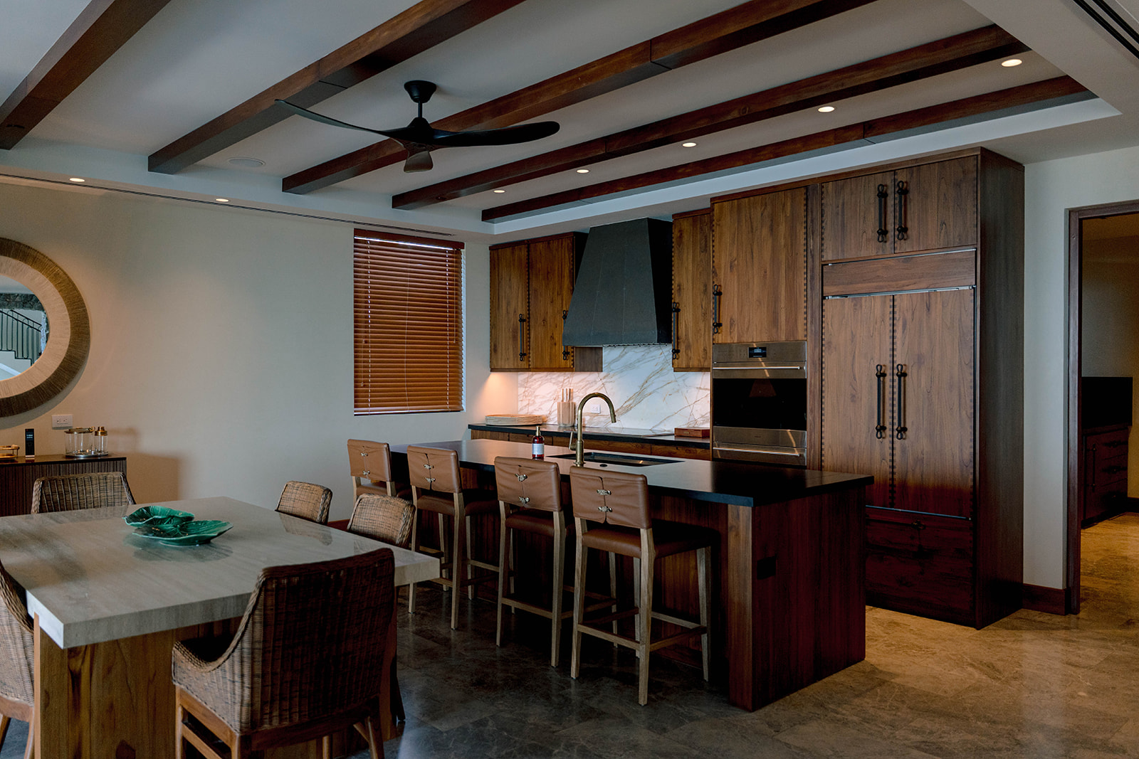 Nekajui Ritz Carlton Reserve kitchen with island, wood cabinets, and ceiling beams.