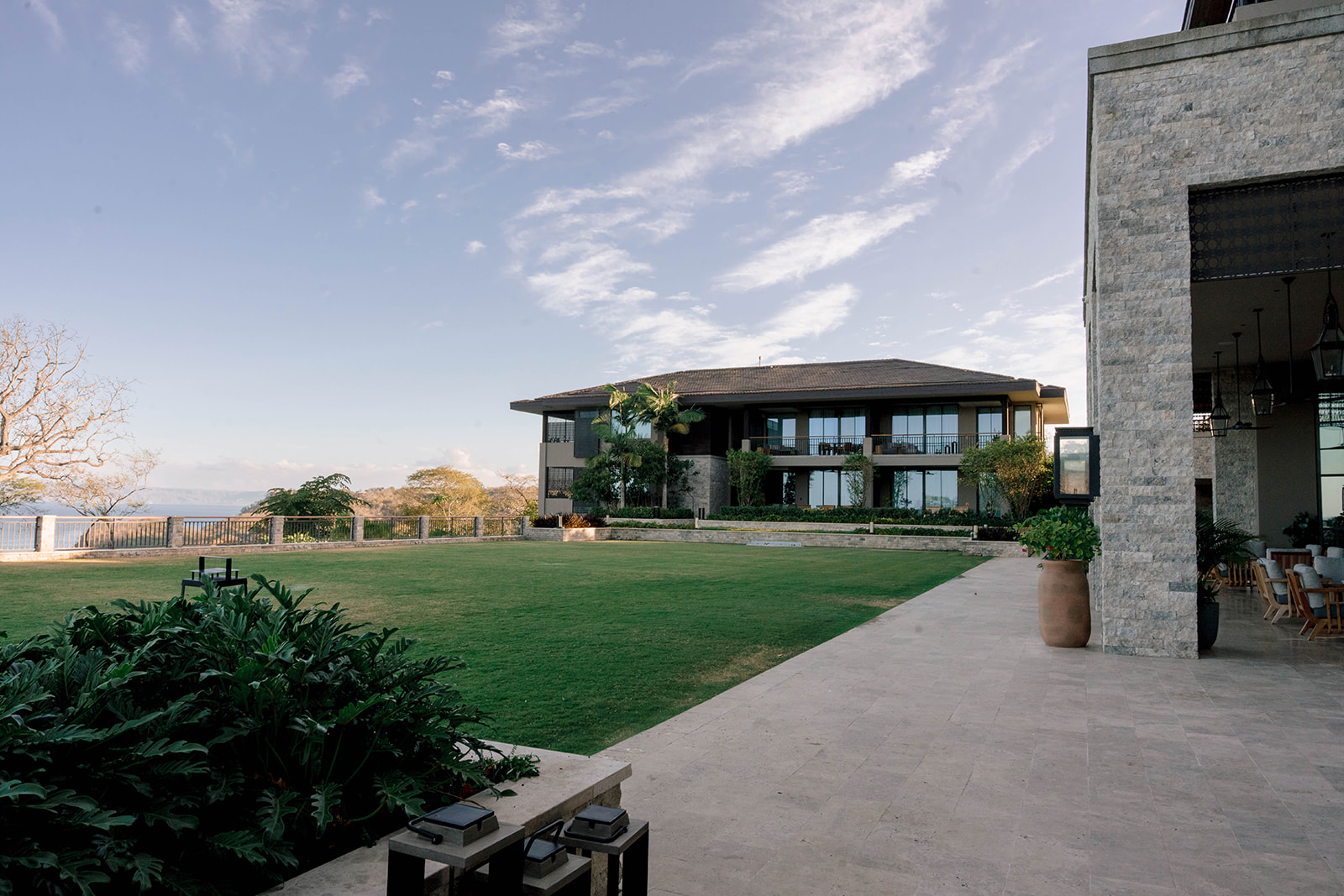 Nekajui, a Ritz-Carlton Reserve, features a modern building with a large lawn and patio area.