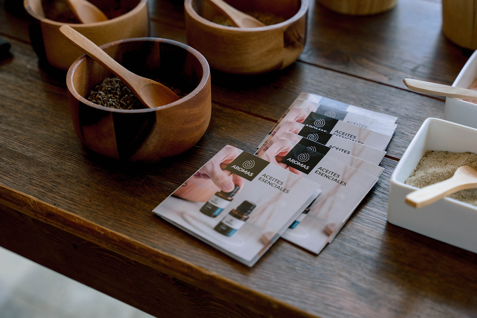 Wooden bowls with spices and Aromas Aceites Esenciales brochures at Nekajui, a Ritz Carlton Reserve.