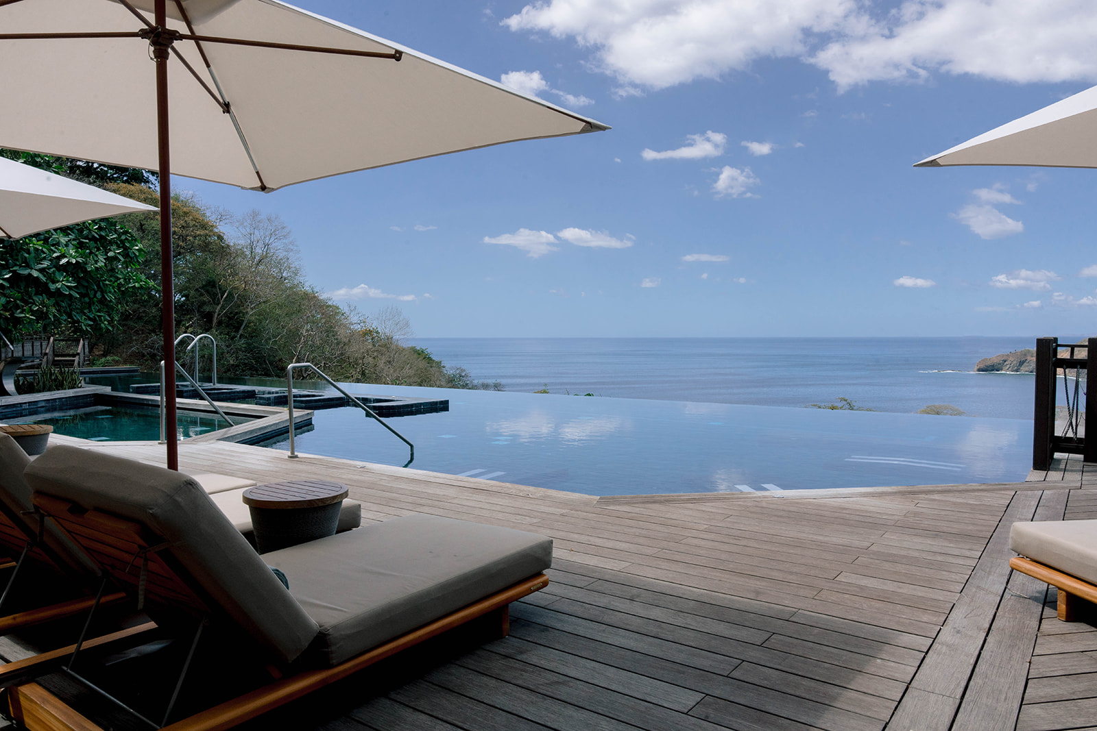 Nekajui Ritz Carlton Reserve: Infinity pool overlooking the ocean with lounge chairs and umbrellas.