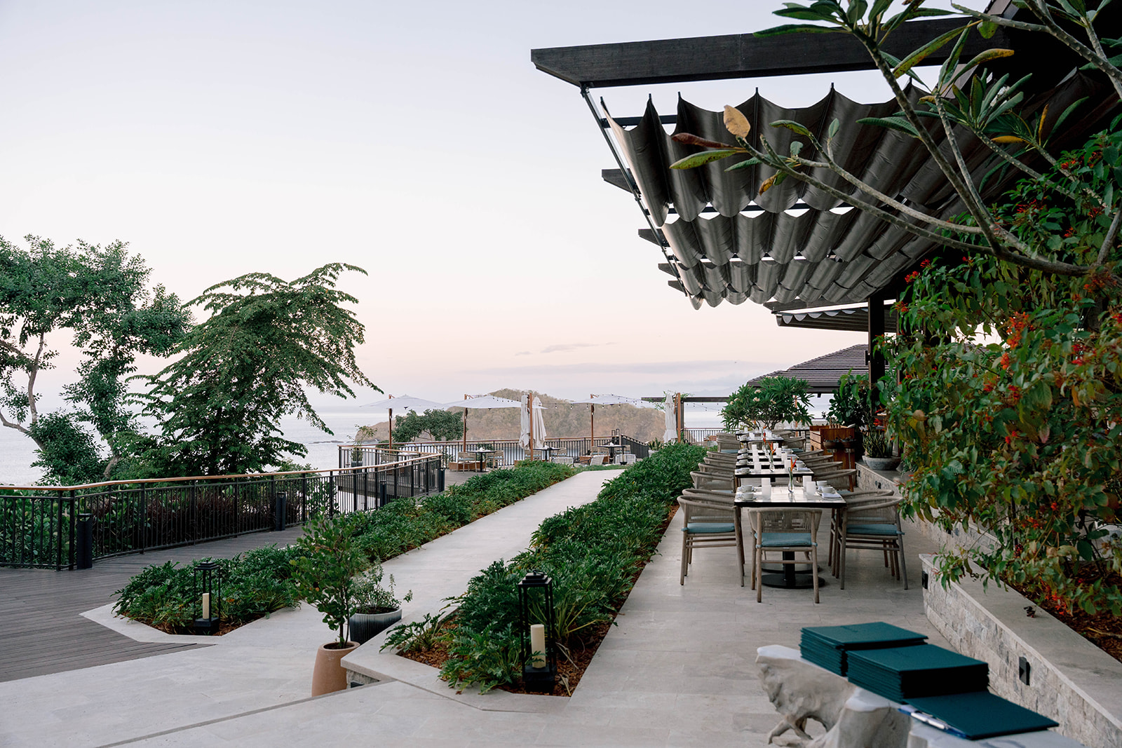 Outdoor dining at Nekajui, a Ritz Carlton Reserve, with ocean views and lush landscaping.